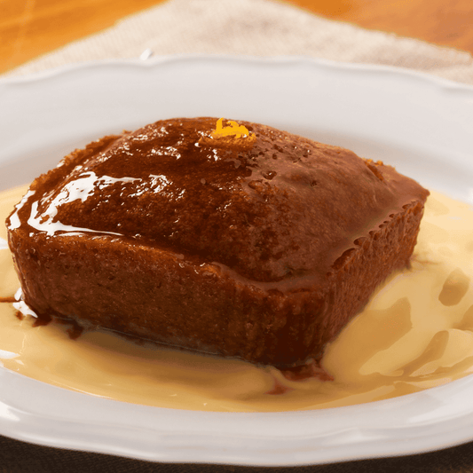 Brown dessert with a glossy top on a white plate with a beige napkin